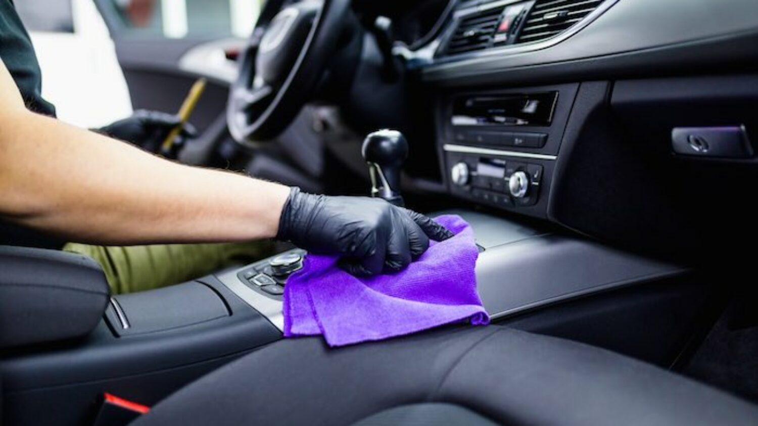 A man cleaning car interior, car detailing (or valeting) concept. Selective focus.